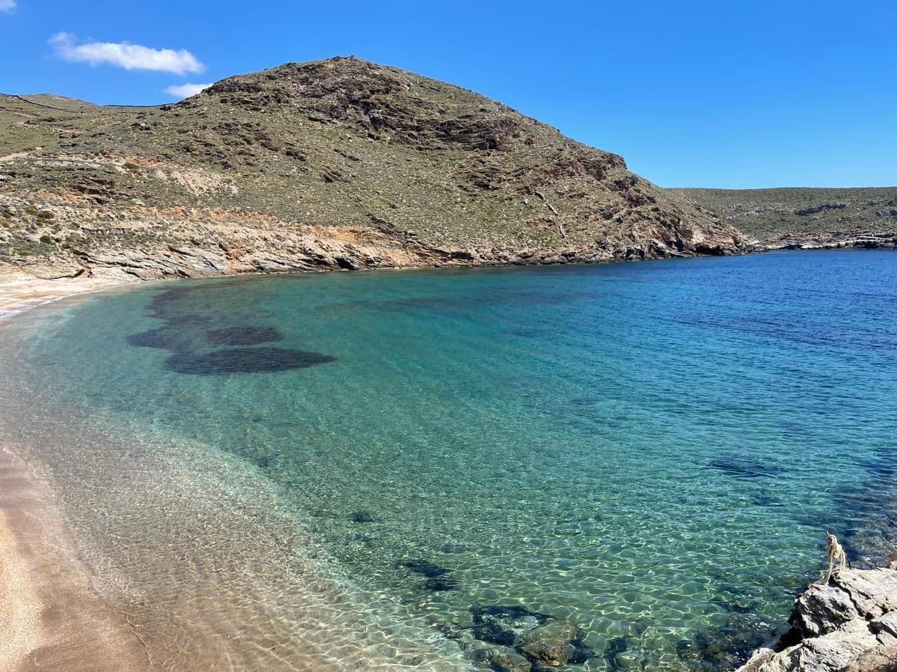 The beachfront at Schinos on the island of Kea, clear turquoise water below dry hills